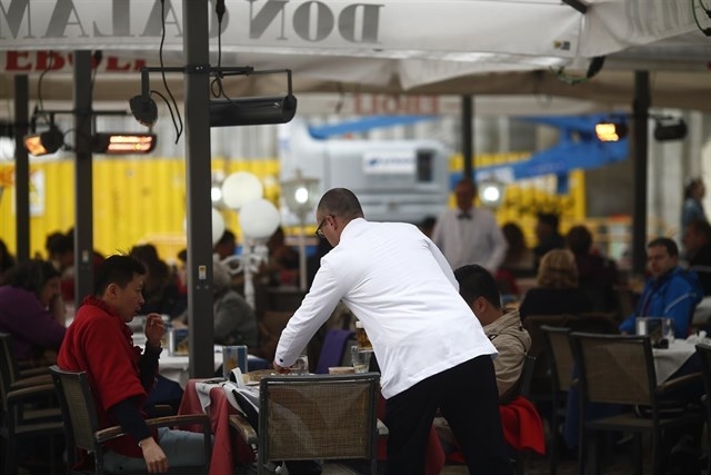 Un camarero, en una terraza de un bar.